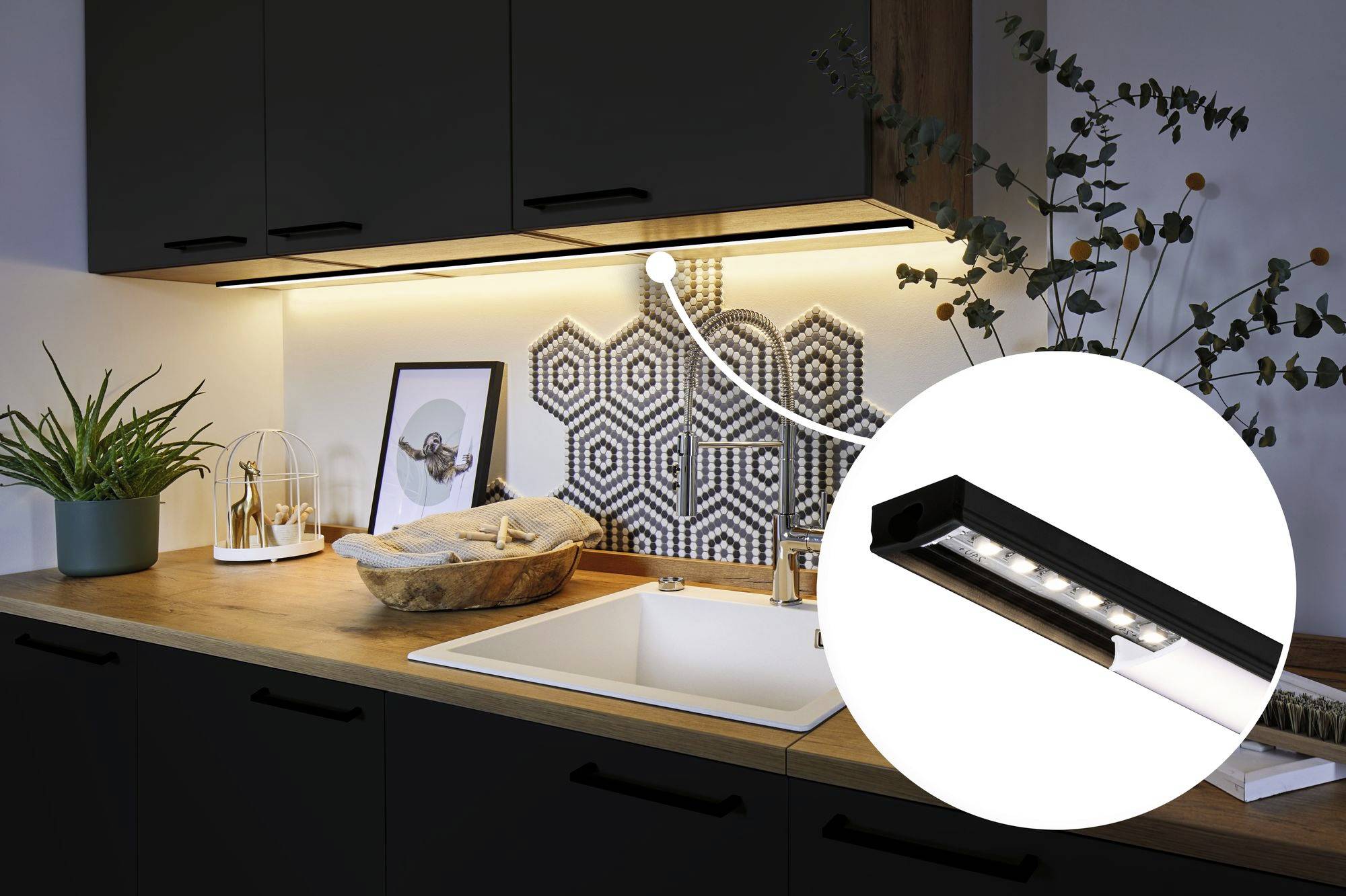 Moderne Küche mit Holzarbeitsplatte, weißem Waschbecken und dekorativen Fliesen. Nahaufnahme zeigt LED-Unterbaulichtleiste.