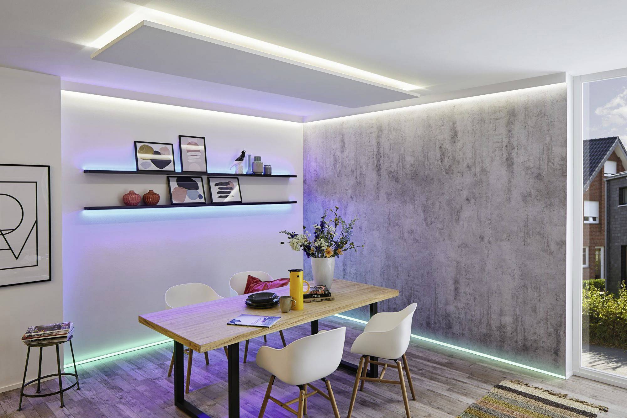 Ein modernes Esszimmer mit Holztisch, weißen Stühlen und an der Wand angebrachten, beleuchteten Regalen mit Dekorationen und Pflanzen.