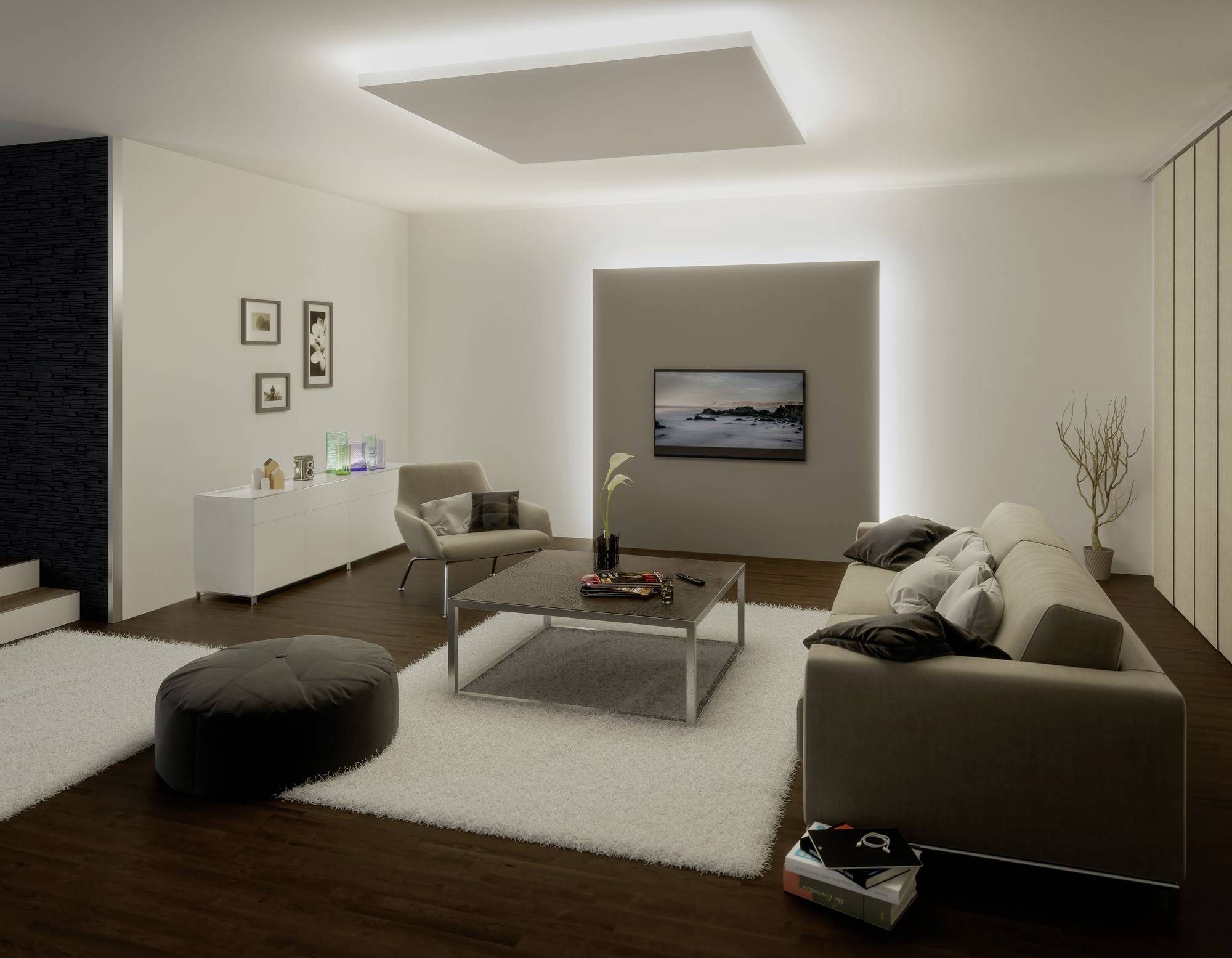 Ein modernes Wohnzimmer mit beigen Sofas, einem Couchtisch, einem Flachbildfernseher an der Wand und einem Teppich auf Holzboden.