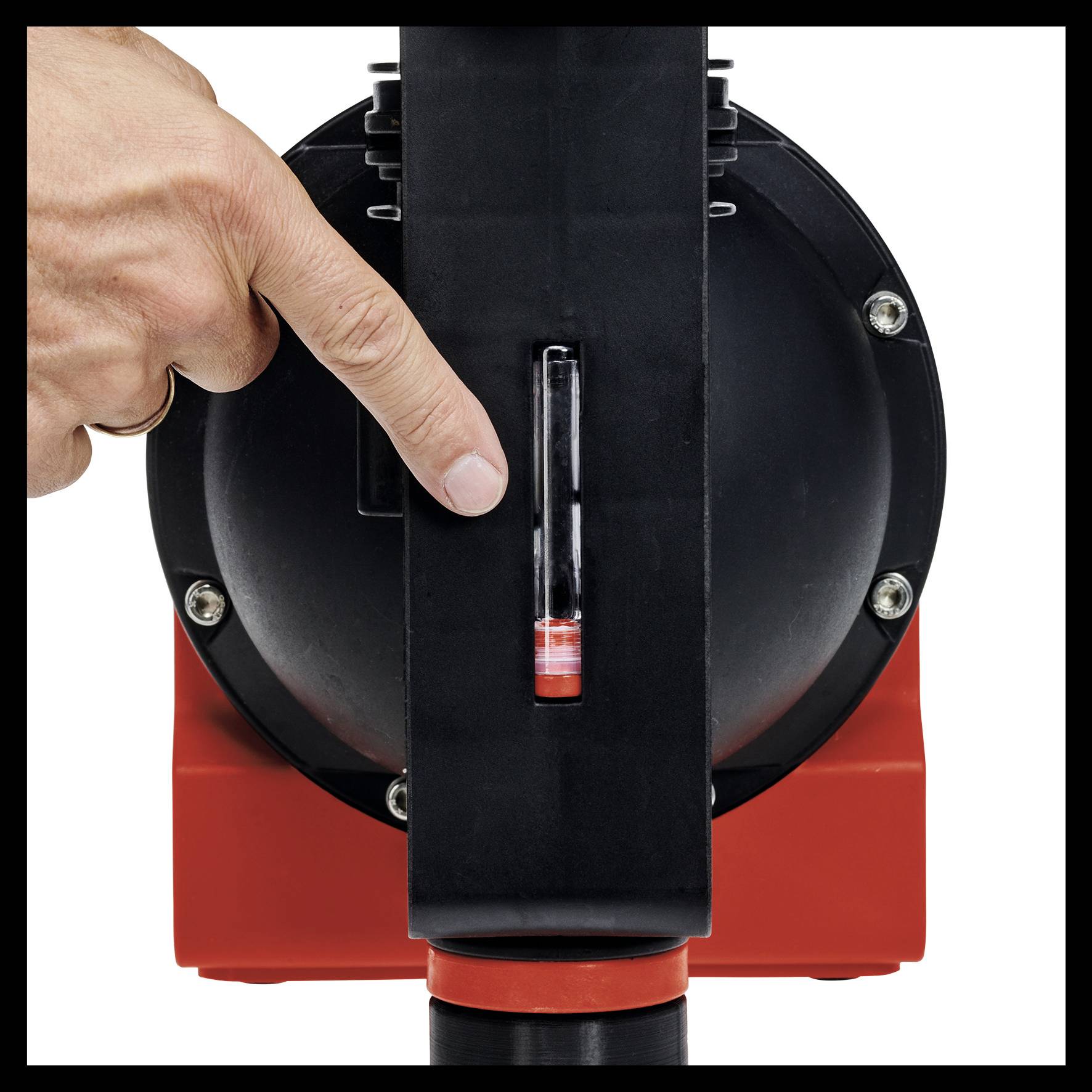 Eine Hand zeigt auf ein rundes, schwarzes Gerät mit einem kleinen, transparenten Röhrchen, das eine rote Flüssigkeit enthält.