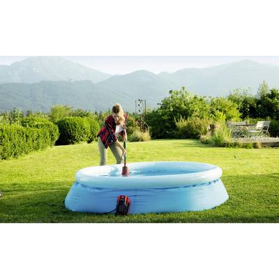 Eine Person reinigt ein aufblasbares Planschbecken mit einer Bürste in einem Garten mit Bergblick im Hintergrund.