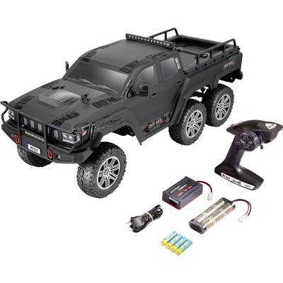 Ferngesteuerter, sechsrädriger, schwarzer Offroad-Truck mit Zubehör: Fernsteuerung, Ladegerät, Batteriepacks und Kabel.