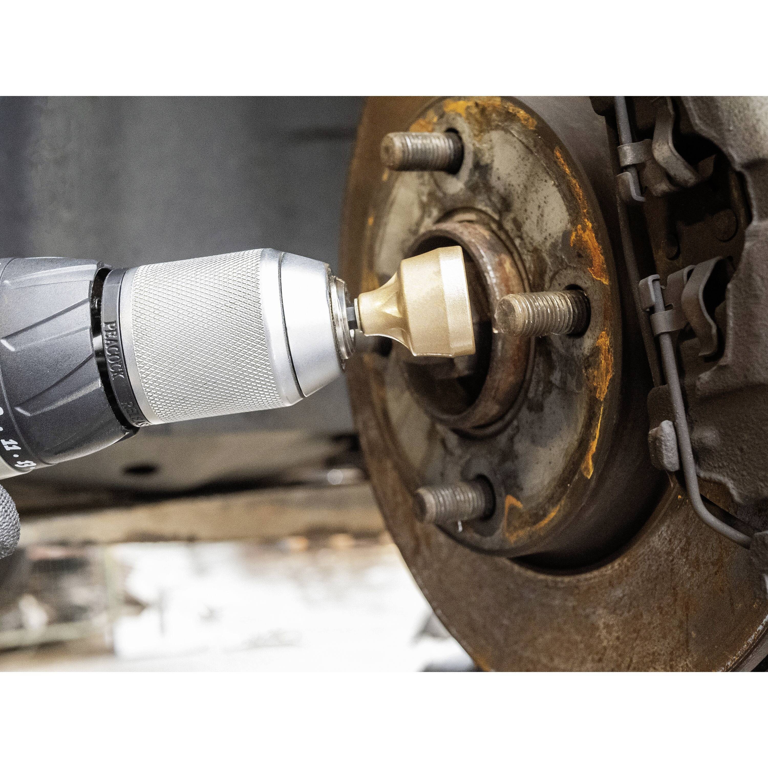 'Bohren eines Metallgegenstands mit einem Bohrer, befestigt an einem Rad.'