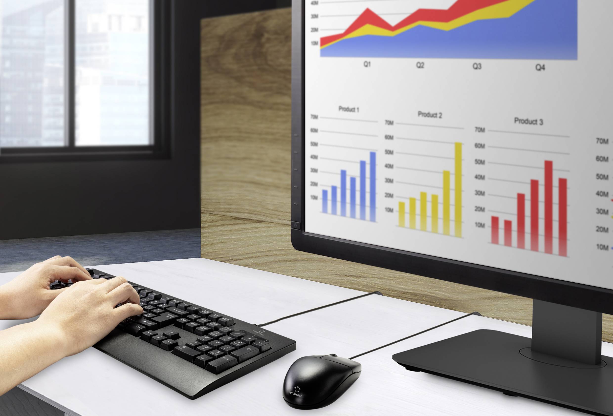 Person tippt auf Tastatur vor Monitor mit bunten Balken- und Liniendiagrammen. Diagramme zeigen vierteljährliche Verkaufsdaten.