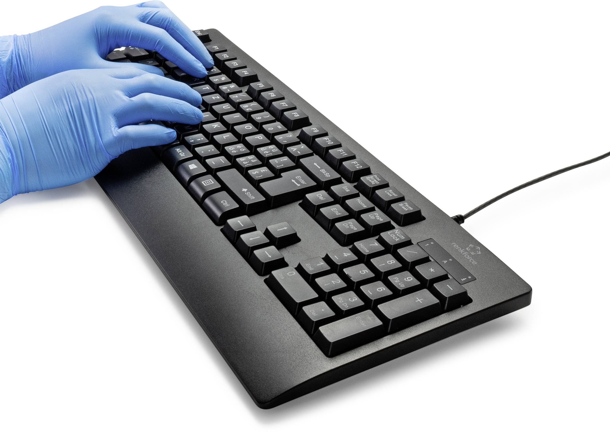 Hände in blauen Handschuhen tippen auf einer schwarzen Computertastatur, die mit einem USB-Kabel verbunden ist.