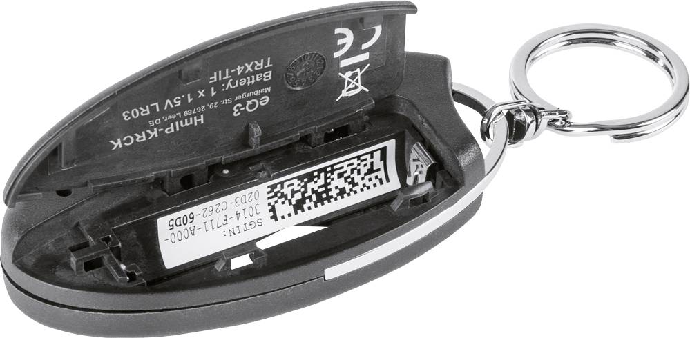 Ein geöffneter Autoschlüssel zeigt das Batteriefach mit sichtbarer Batterie und QR-Code im Inneren, Schlüsselanhänger rechts sichtbar.