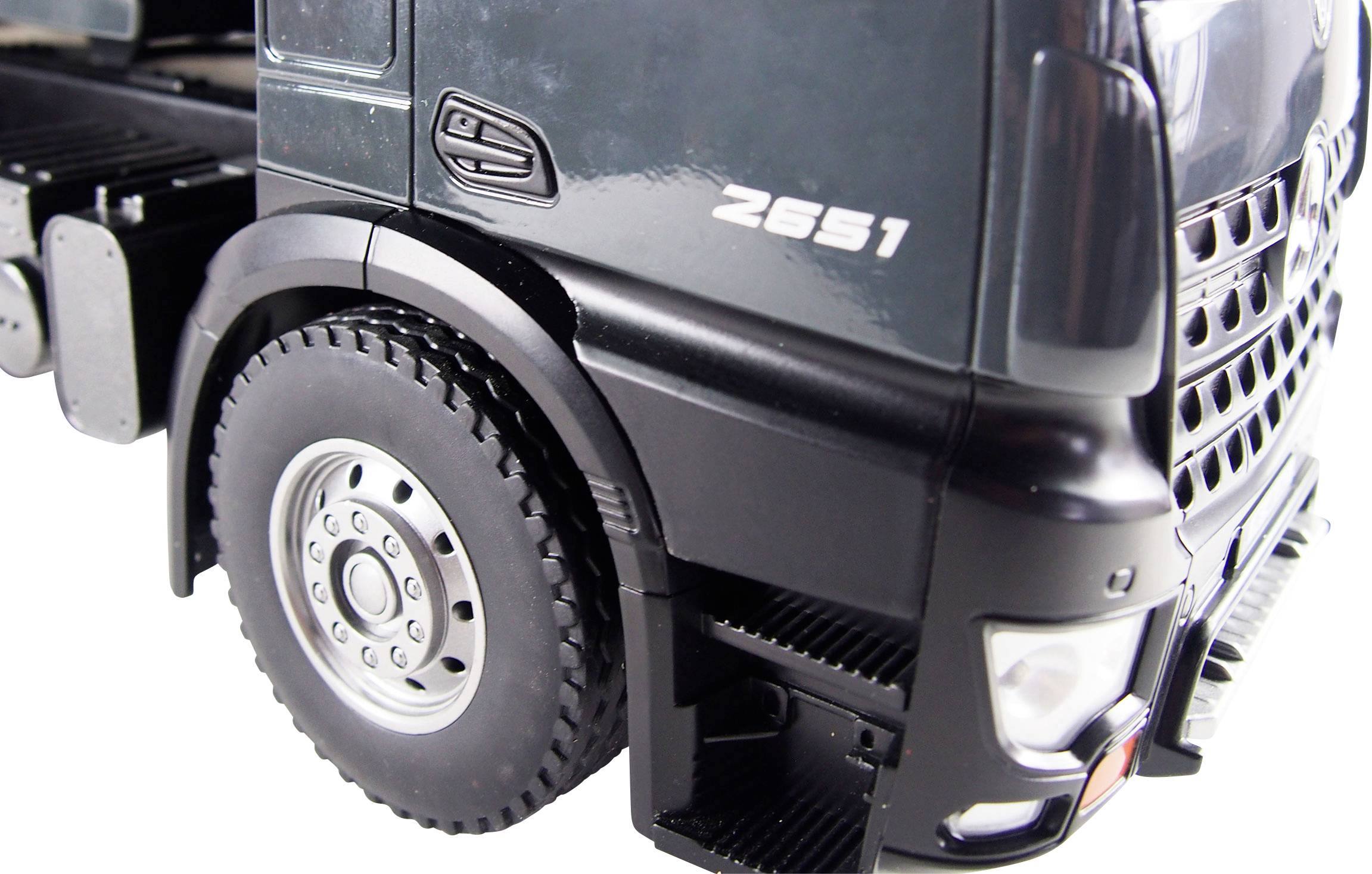 Teilansicht eines schwarzen Lkw-Modells. Sichtbar sind Vorderreifen, Stoßstange und Teile der Fahrerkabine mit der Aufschrift 'Z651'.
