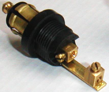 Ein schwarzes, rundes elektrisches Bauteil mit zwei goldfarbenen Schrauben, das auf einem weißen Hintergrund liegt.