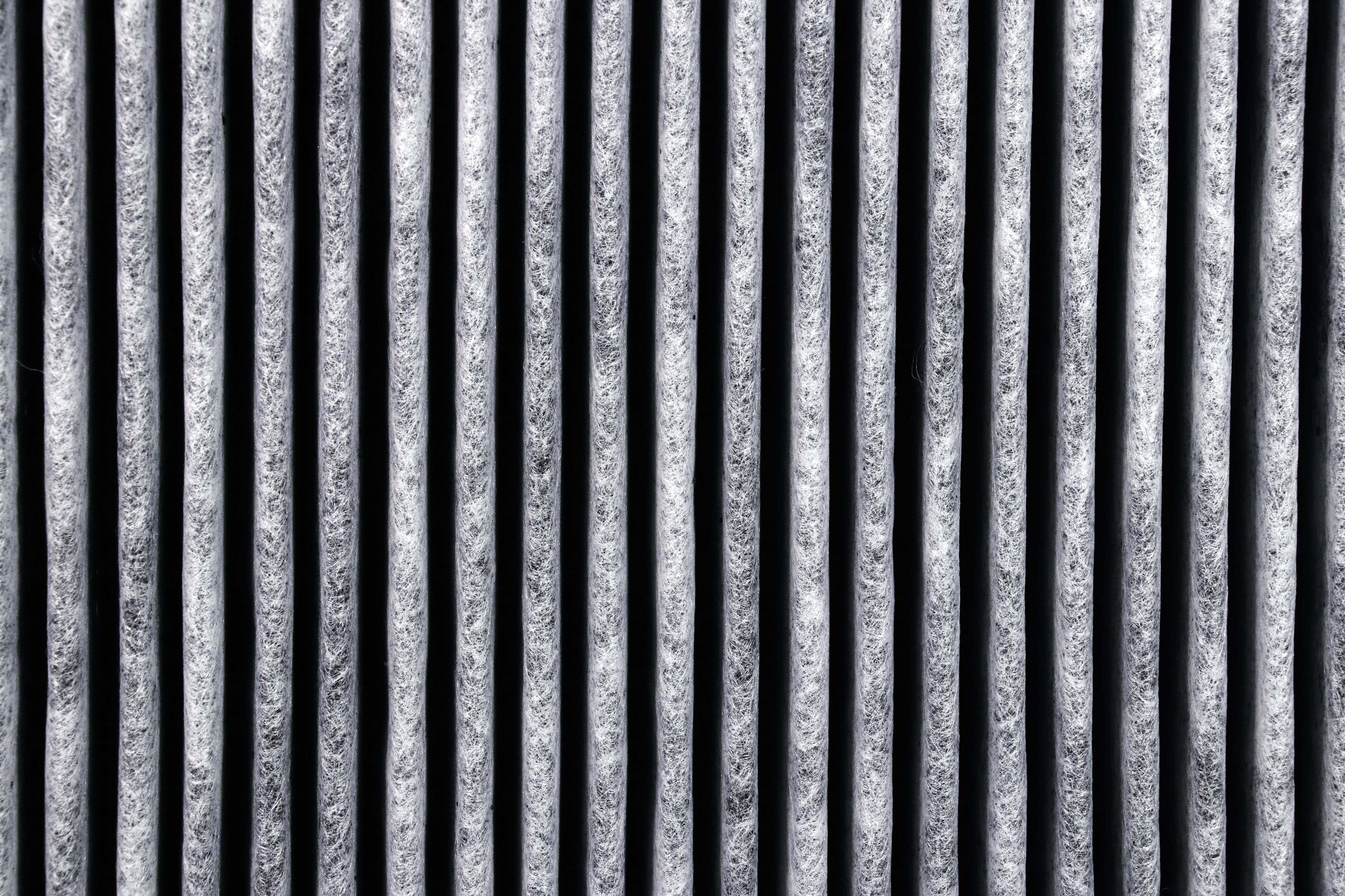 Nahaufnahme einer gefalteten, texturierten Oberfläche mit vertikalen Linien in Grau und Schwarz.