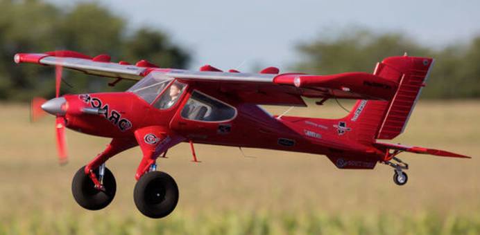 Avion miniature en survol à basse altitude L'image montre un modèle réduit d'avion rouge de type DRACO en survol lent et à basse altitude.