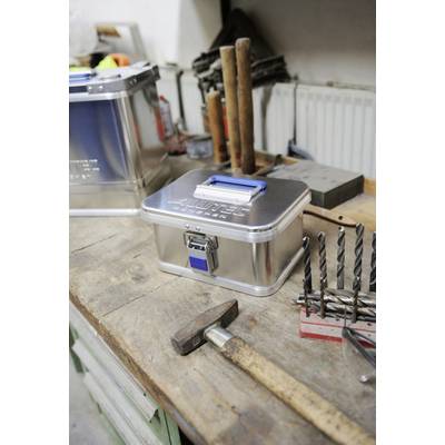 Werkbank mit Metallkiste, Hammer und Bohrer. Im Hintergrund sind weitere Werkzeuge zu sehen. Atmosphäre einer Werkstatt.