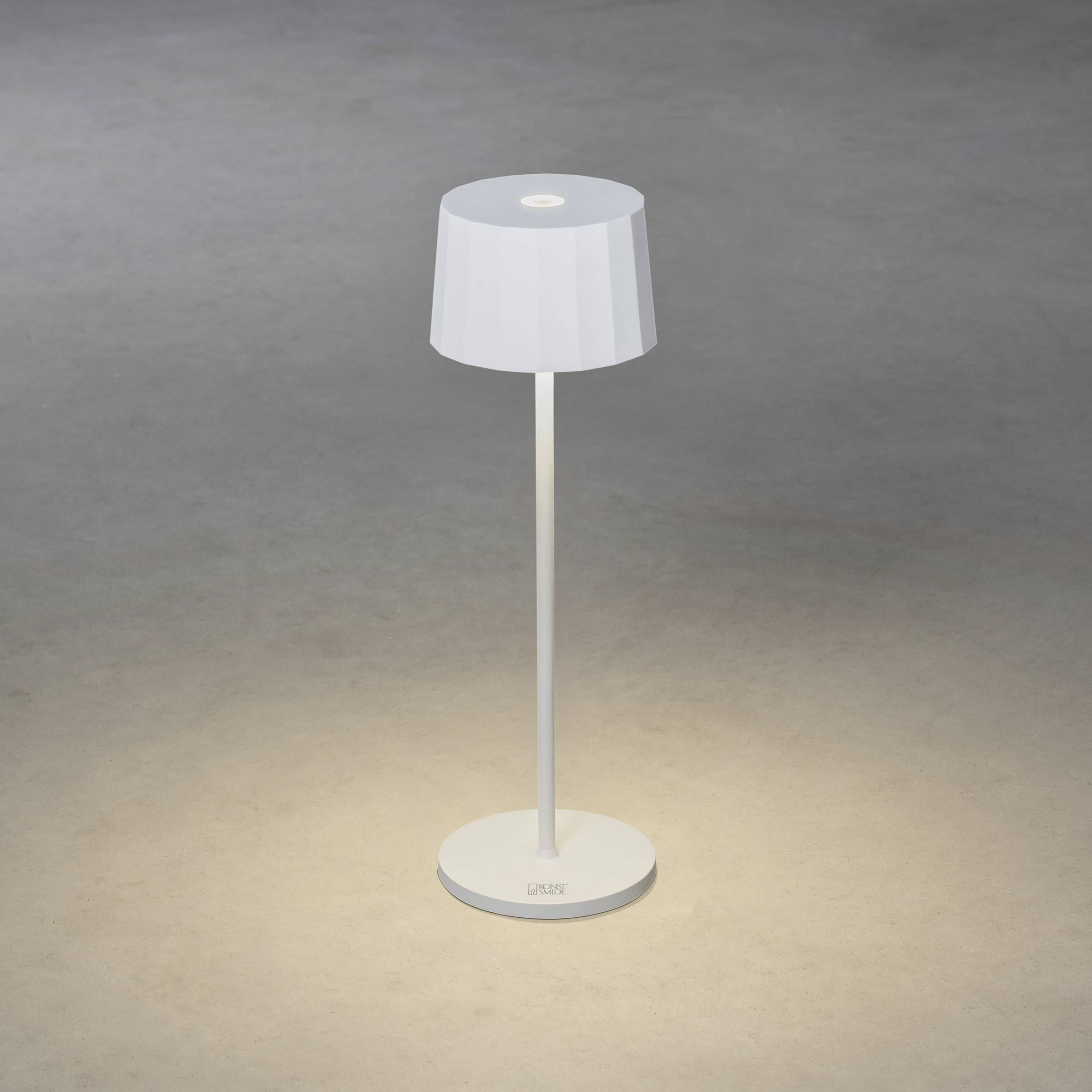 Stehende weiße Lampe auf grauem Boden, Lichtschein darauf gerichtet. Minimalistisches Design, geeignet für modernes Interieur.