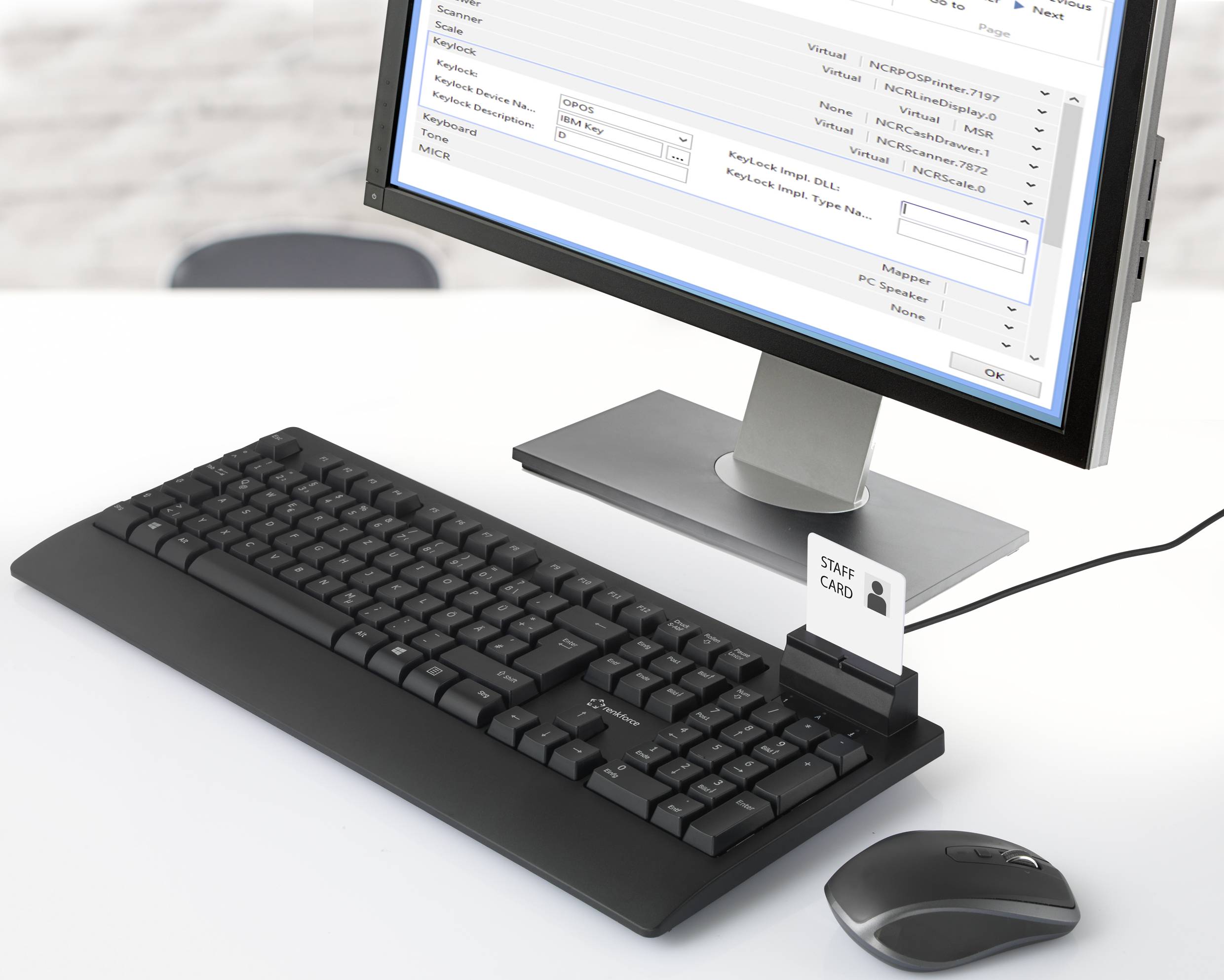 Ein Computer mit einer angeschlossenen Tastatur und Maus zeigt ein Programmfenster an. Eine 'STAFF CARD' steckt im Kartenleser.