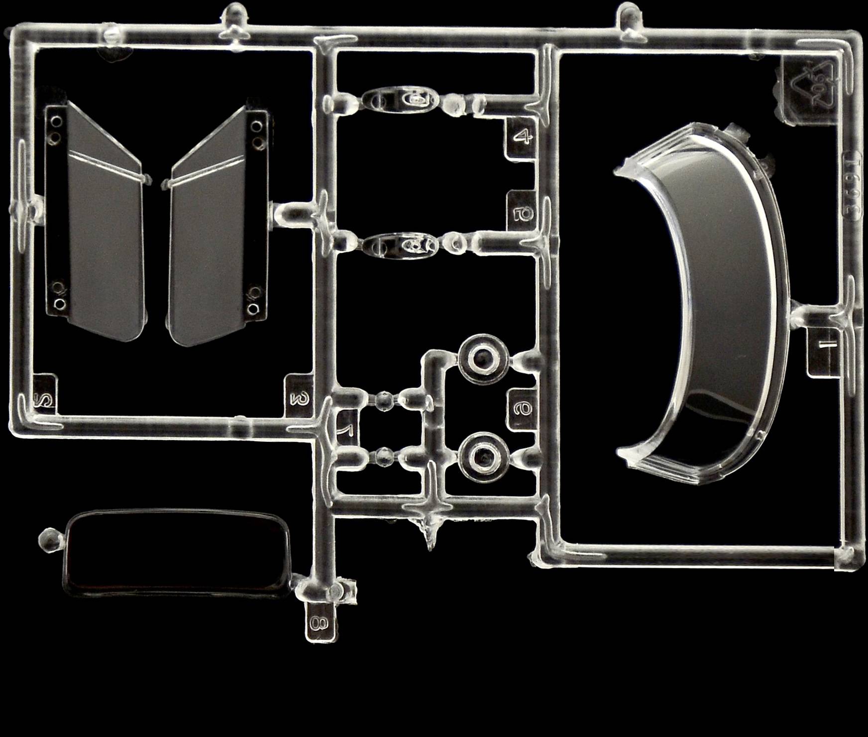 Plastikteile auf einem Rahmen; möglicherweise Teil eines Modellbausatzes. Transparente Bauteile, teils gebogen, auf schwarzem Hintergrund.