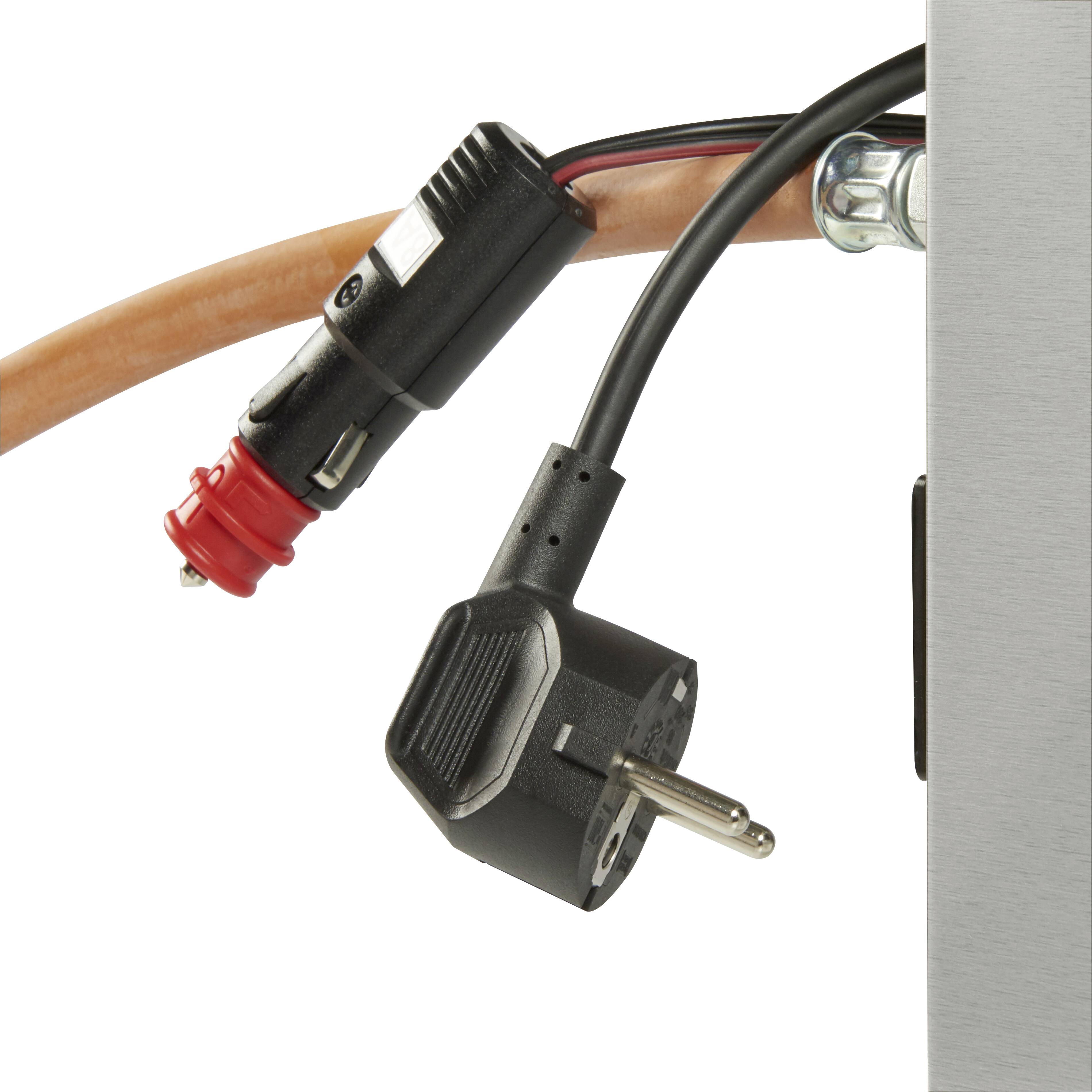 Ein schwarzer und roter Elektrokabelstecker ist mit einer silbernen Metalloberfläche verbunden. Ein schwarzer Eurostecker hängt daneben.