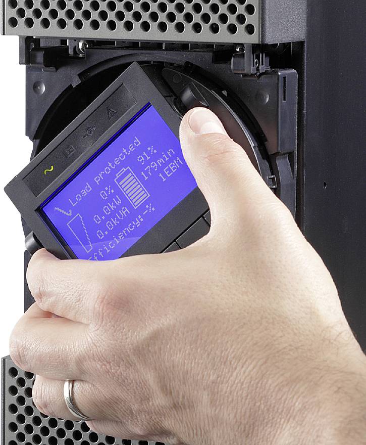 Eine Hand hält ein Datenkassettenteil, das in ein elektronisches Gerät eingeschoben wird. Das Display zeigt technische Daten an.