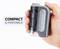 Eine Hand hält ein kompaktes, tragbares Gerät. Auf dem Bild steht 'COMPACT & PORTABLE'. Das Gerät hat eine graue und schwarze Oberfläche.