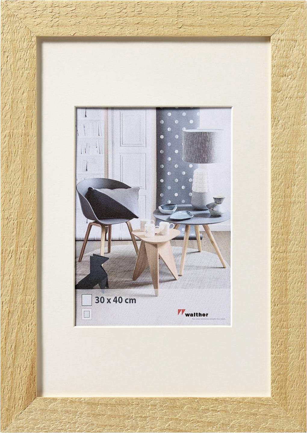 Bilderrahmen aus hellem Holz mit Passepartout, präsentiert ein modern gestaltetes Wohnzimmer mit Stühlen und Tischlampen.