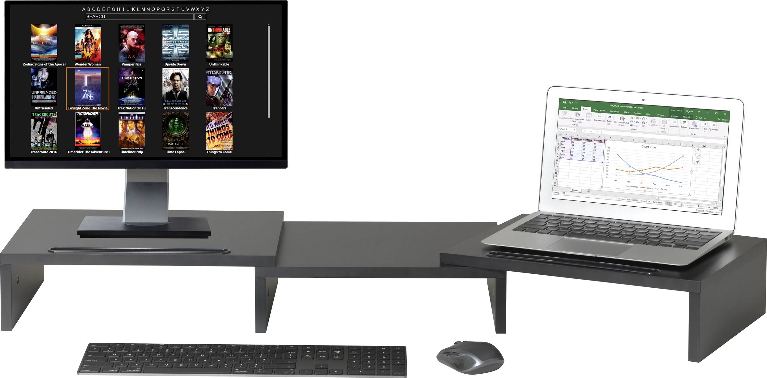 Computer-Arbeitsplatz mit Monitor, auf dem Filme angezeigt werden, und Laptop mit geöffnetem Tabellenkalkulationsprogramm; Tastatur und Maus sichtbar.