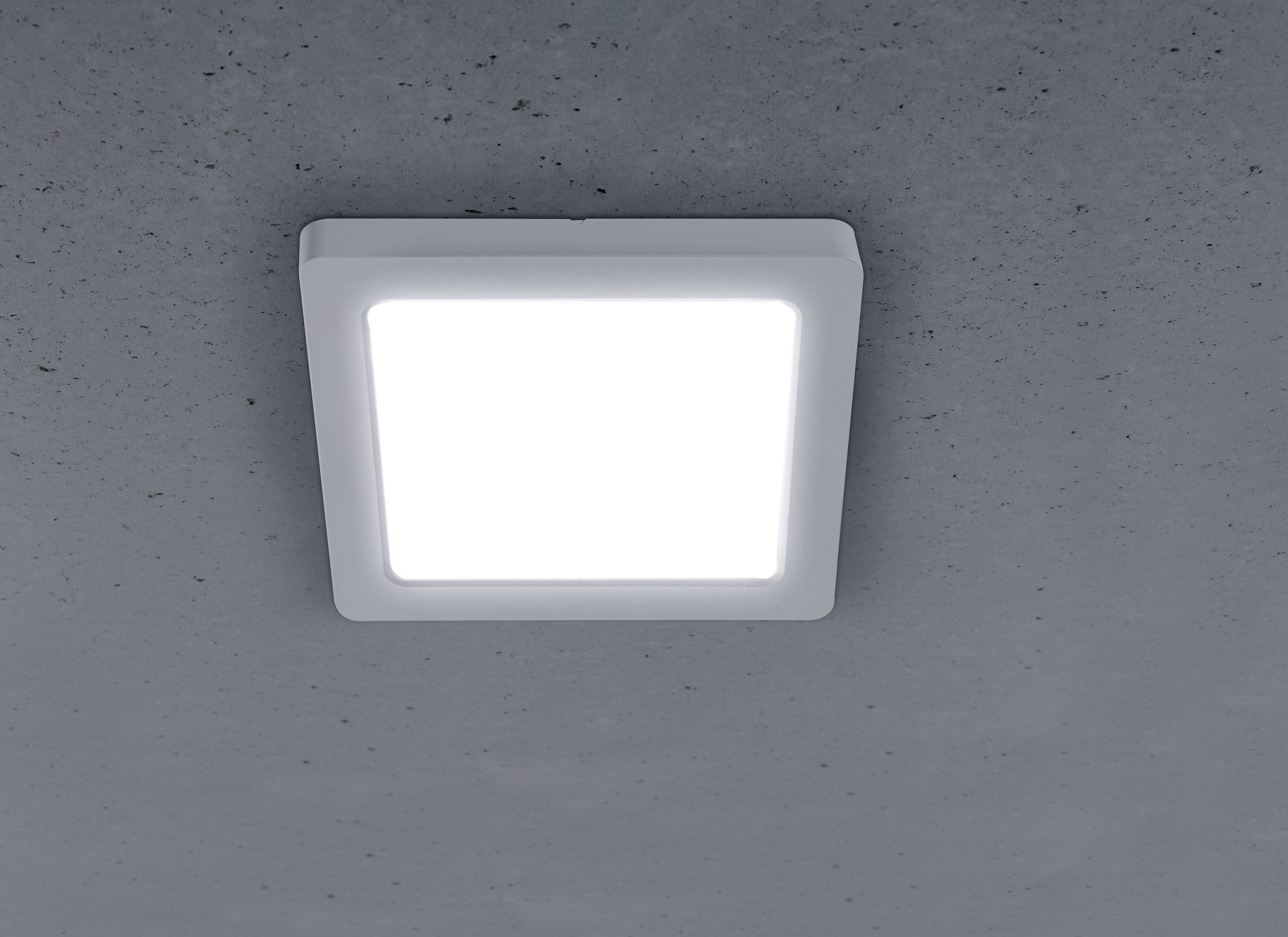 Eine quadratische LED-Deckenleuchte leuchtet hell an einer grauen Decke.