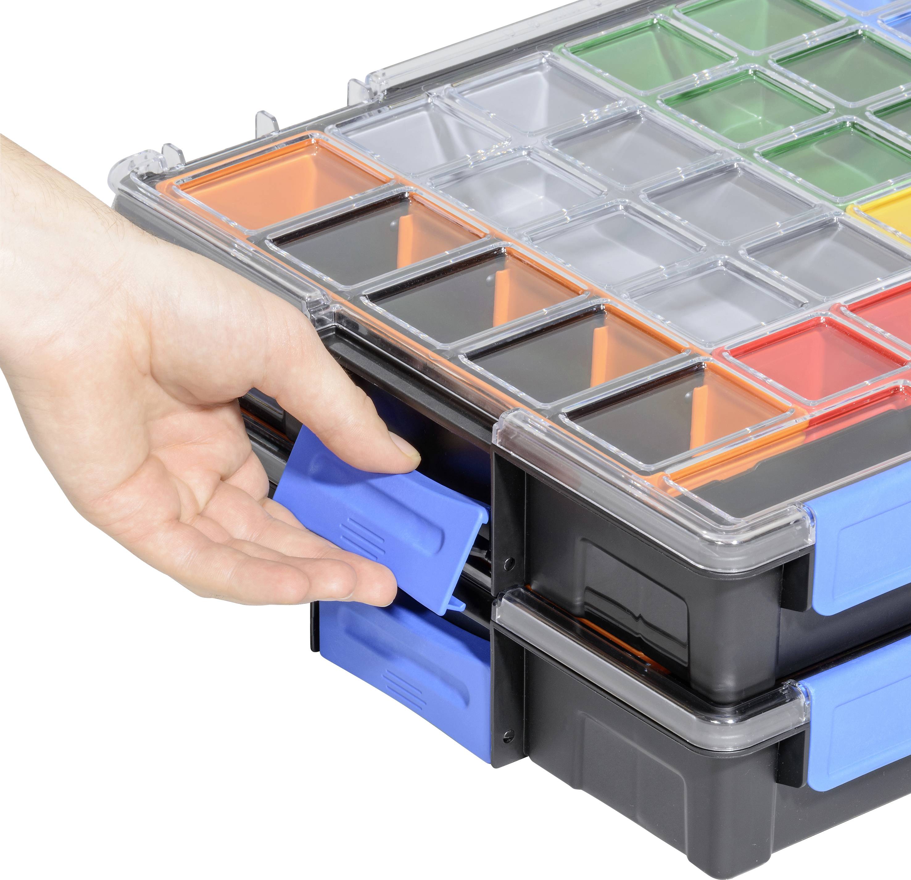 Mehrere Plastikboxen sind gestapelt. Eine Hand entfernt eine blaue Schublade. Oben sind kleine Fächer in mehreren Farben sichtbar.