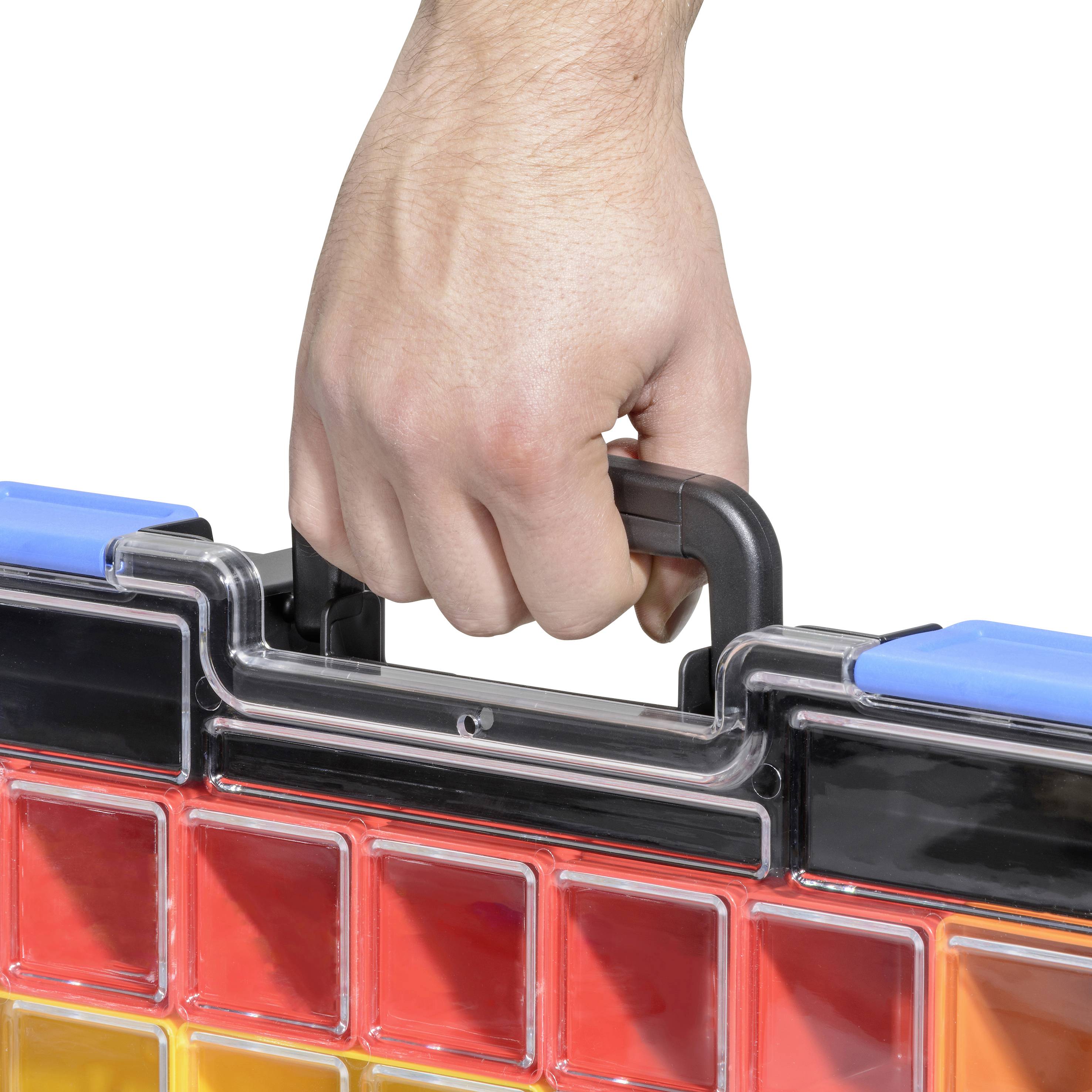 Eine Hand hält den Griff eines Werkzeugkoffers, der unten rote und gelbe Fächer hat.