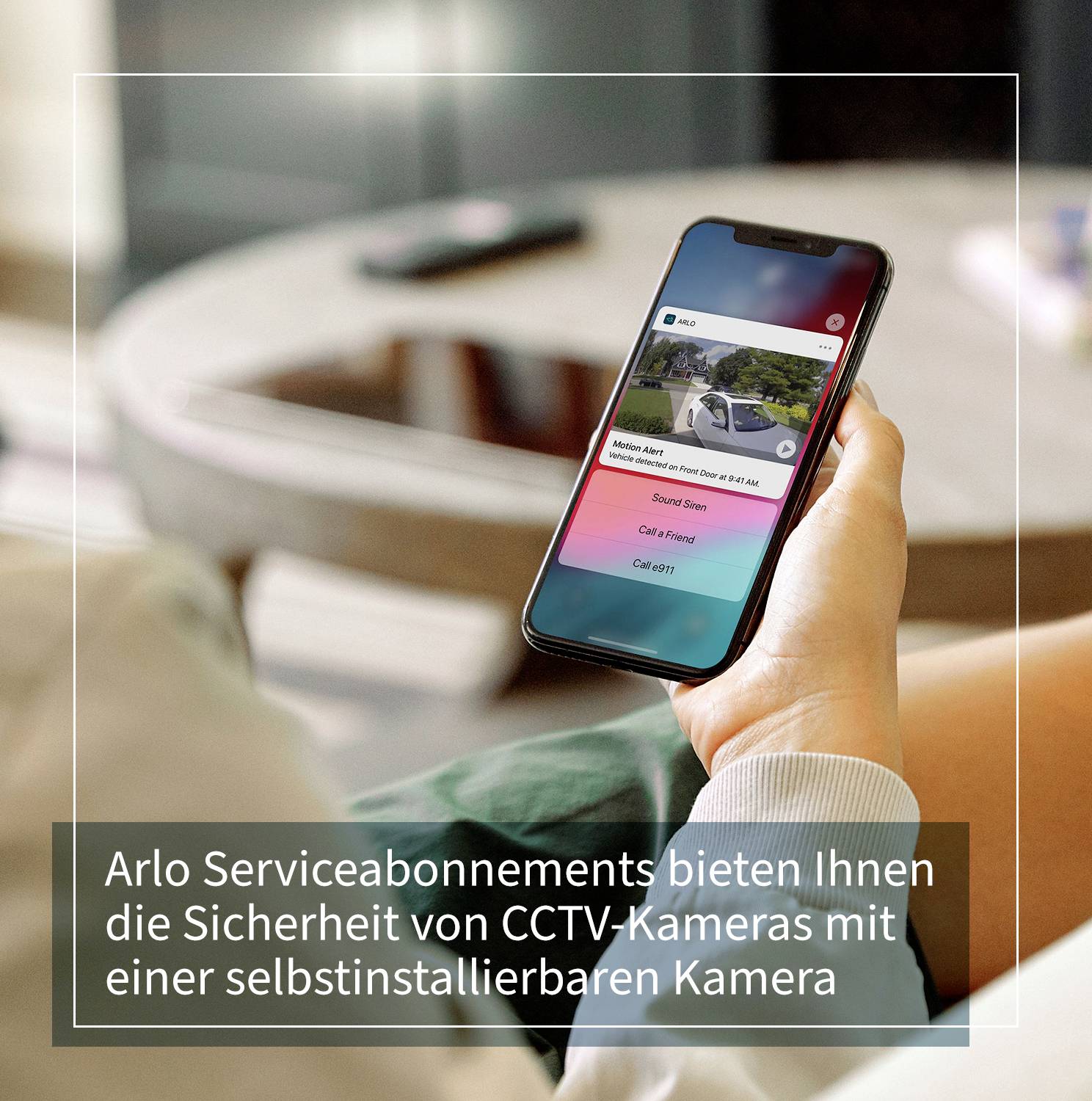 Person hält Smartphone mit Bild einer Kameraüberwachung. Text auf dem Bild: 'Arlo Serviceabonnements bieten Ihnen die Sicherheit von CCTV-Kameras mit einer selbstinstallierbaren Kamera'.