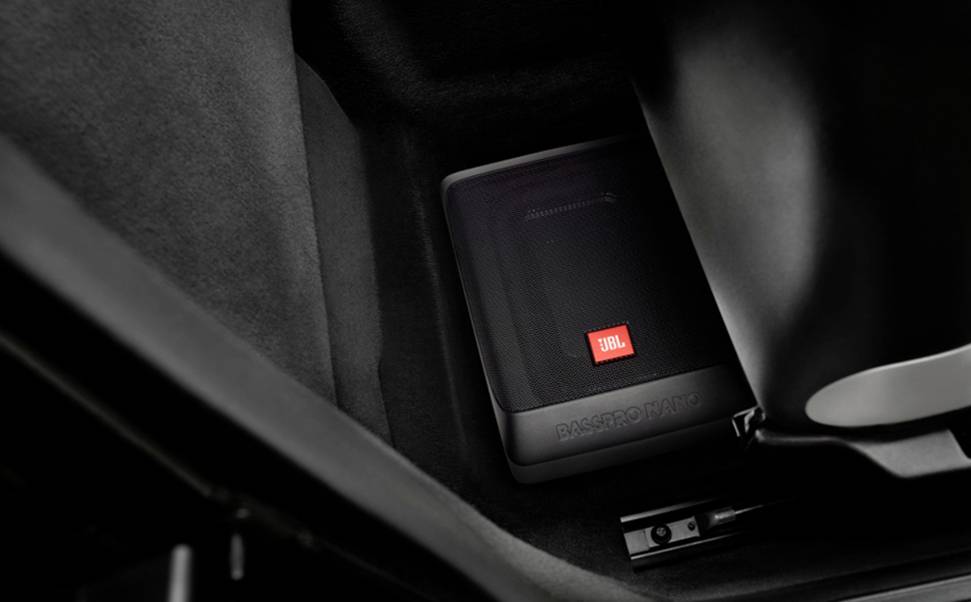 'Ein JBL-Lautsprecher ist im Fußraum eines Autos montiert.'