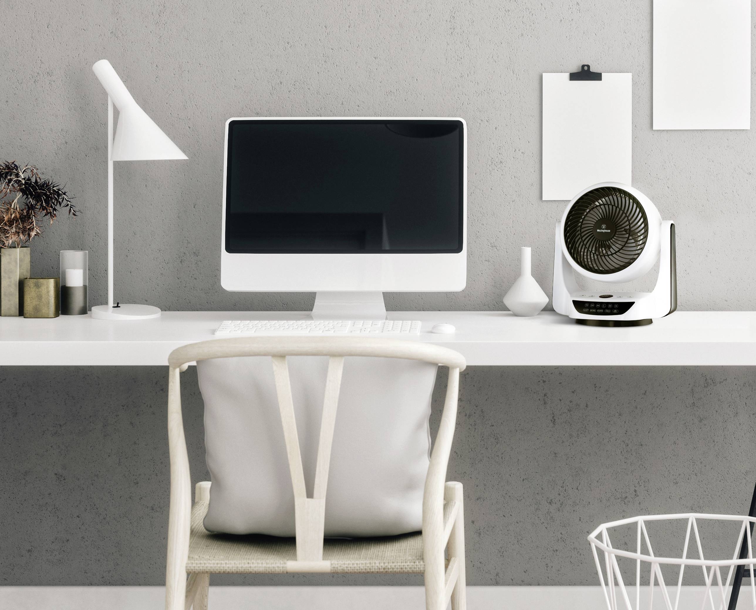 Moderner Schreibtisch mit Computer, Schreibtischlampe, Ventilator und Dekorationen, vor einer grauen Wand. Minimalistisches Design.