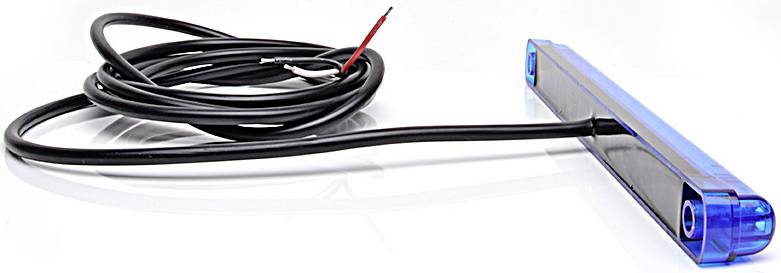 Ein blaues, rechteckiges Gerät mit Kabel, möglicherweise ein Scanner oder Sensor, liegt auf einer weißen Oberfläche.