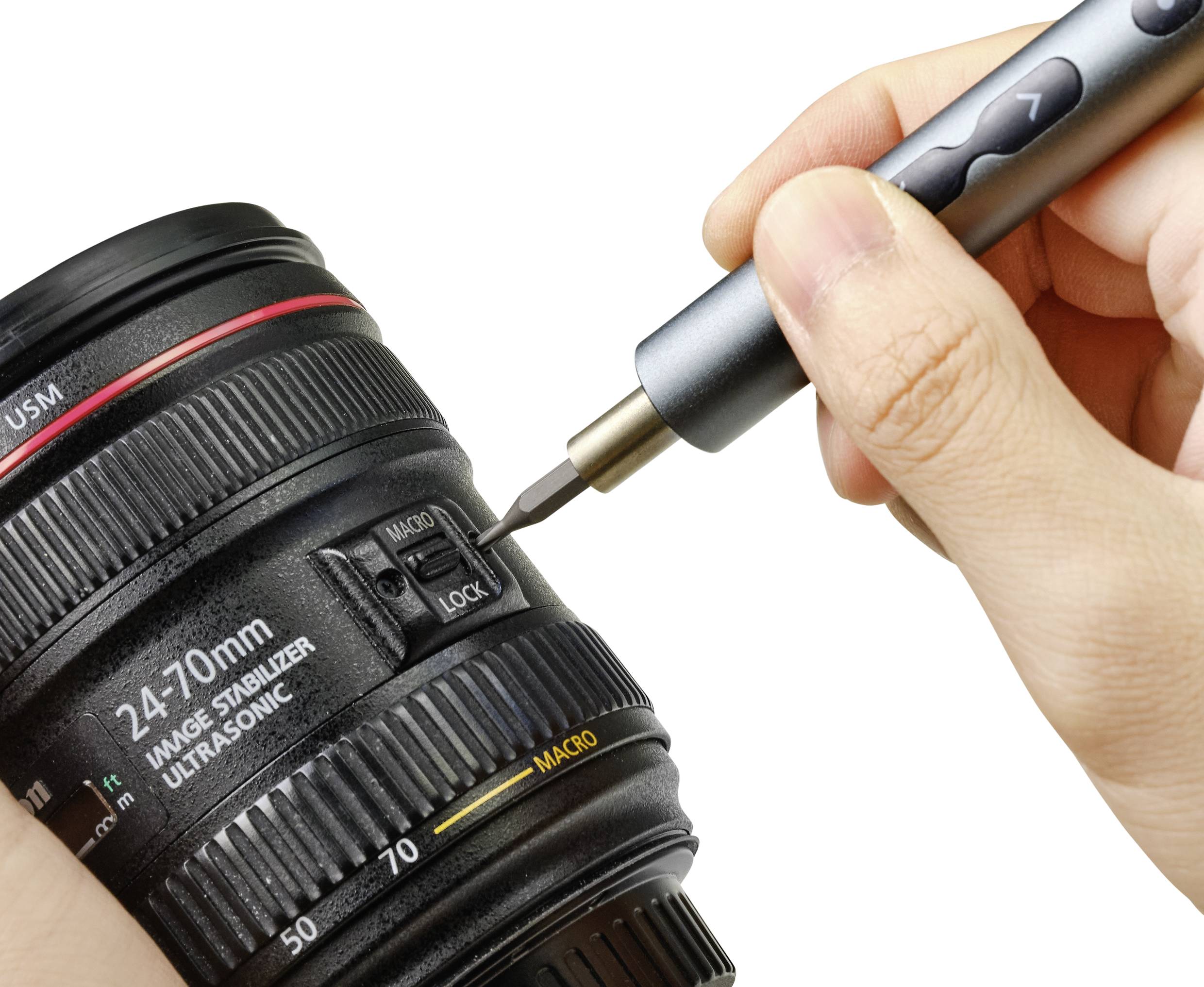 Eine Hand hält ein Kameraobjektiv und eine zweite Hand benutzt einen Pinselstift, um das Innere des Objektivs zu reinigen.