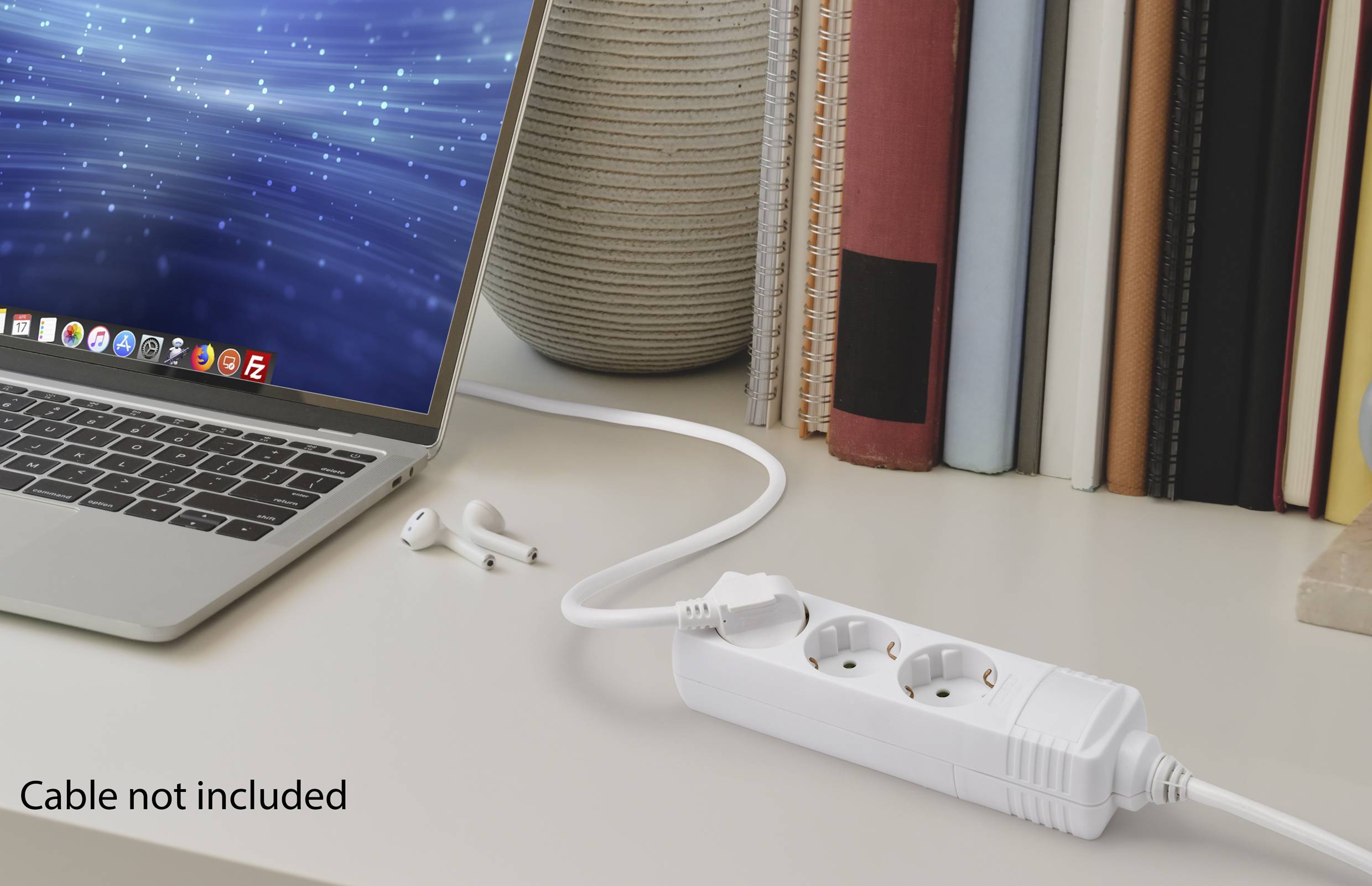 Laptop auf einem Schreibtisch, verbunden mit einer Steckdosenleiste. Rechts im Hintergrund stehen Bücher. Text auf dem Bild: 'Cable not included'.