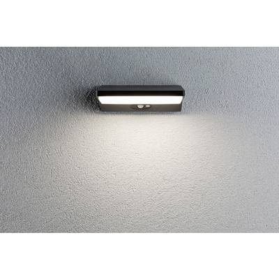 Wandleuchte mit Bewegungssensor an einer strukturierten weißen Wand, strahlt warmes Licht nach unten.