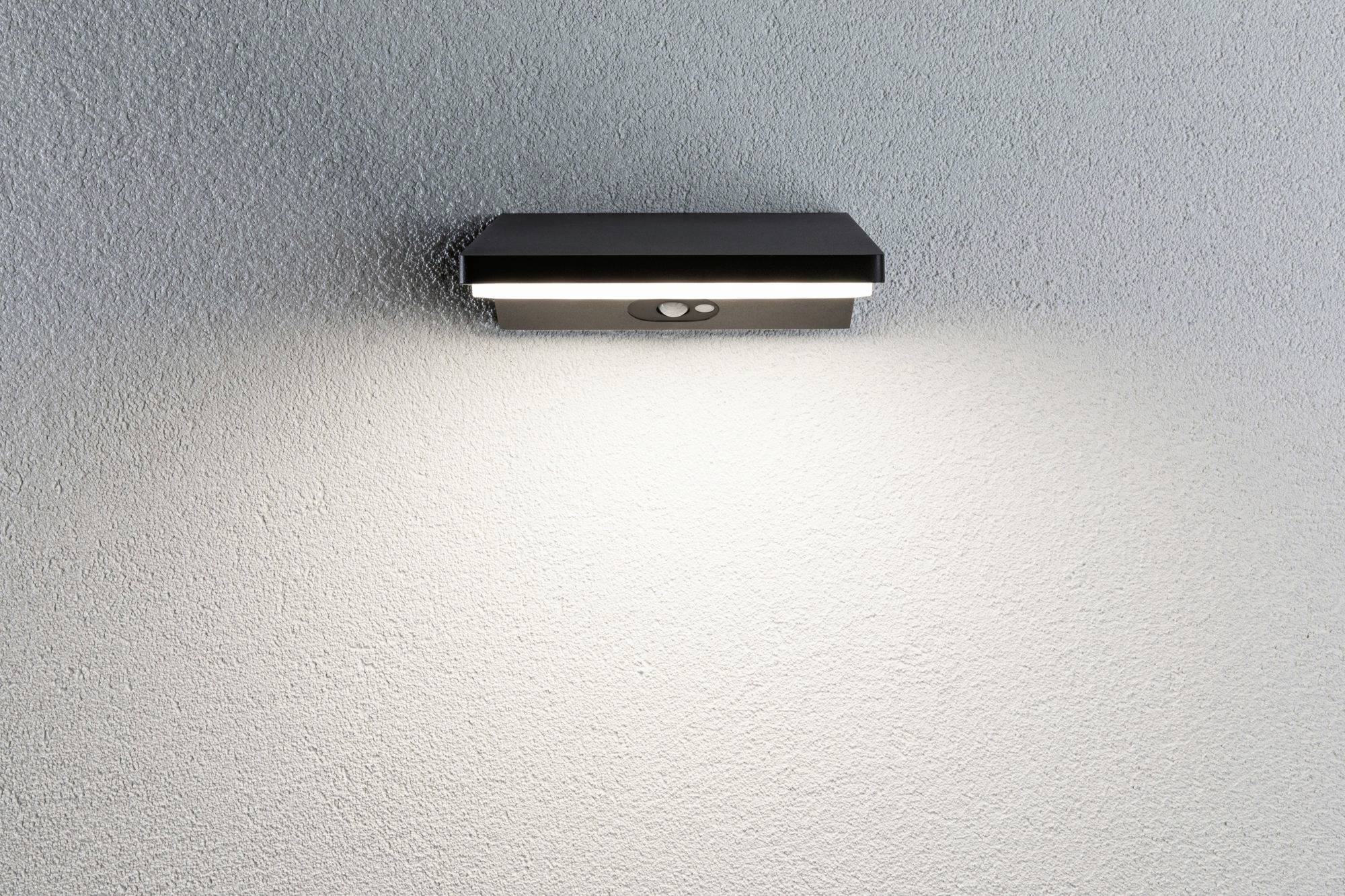 LED-Außenwandleuchte an weißer Wand, strahlt Licht in verschiedenen Richtungen aus.