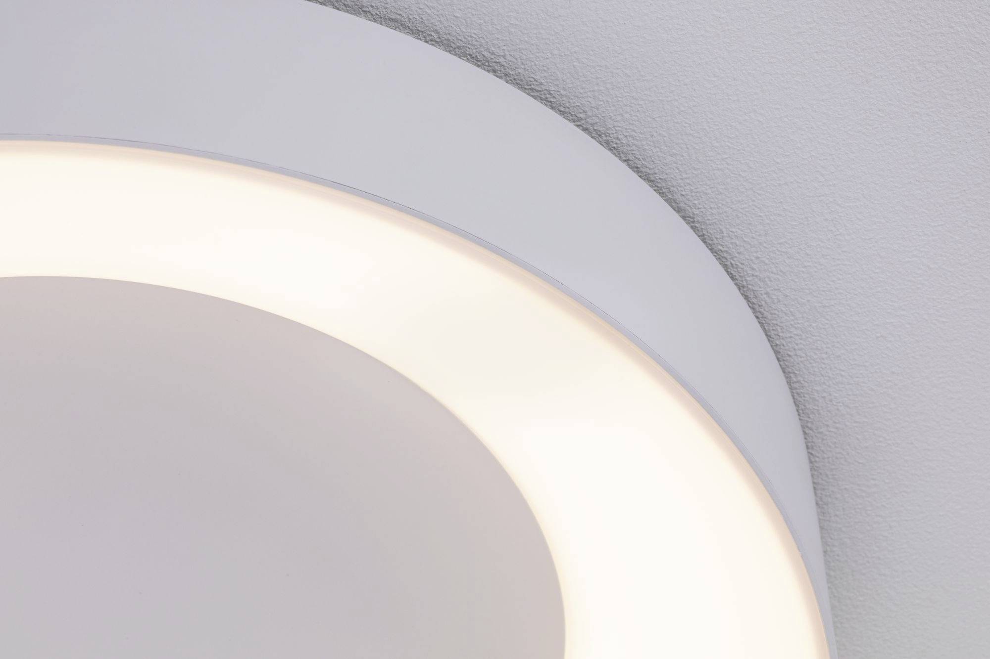 Eine runde, moderne LED-Deckenleuchte leuchtet in warmweißem Licht auf einer glatten, grauen Decke.