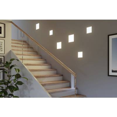 Holztreppe mit Glasgeländer, beleuchtet durch quadratische Lichter in der Wand. Pflanze und gerahmtes Bild an den Wänden.