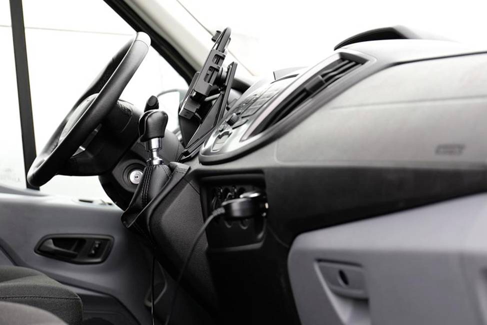Innenansicht eines Auto-Cockpits mit Lenkrad und Armaturenbrett, Handyhalterung neben dem Lenkrad.