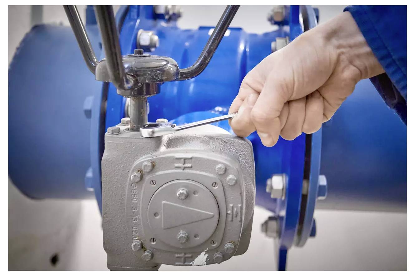 Ein orange-schwarzer Roboter-Rasenmäher mit robusten Reifen und Steuertasten oben, entwickelt für automatisches Mähen.