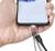 Ein Smartphone wird in der Hand gehalten; ein Ladegerät nähert sich dem Ladeanschluss, was auf ein Ladevorgang hindeutet.