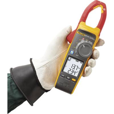 Eine behandschuhte Hand hält ein Digital-Multimeter mit Zangenfunktion, das Messwerte auf einem Display zeigt. Hauptfarbe: Gelb.