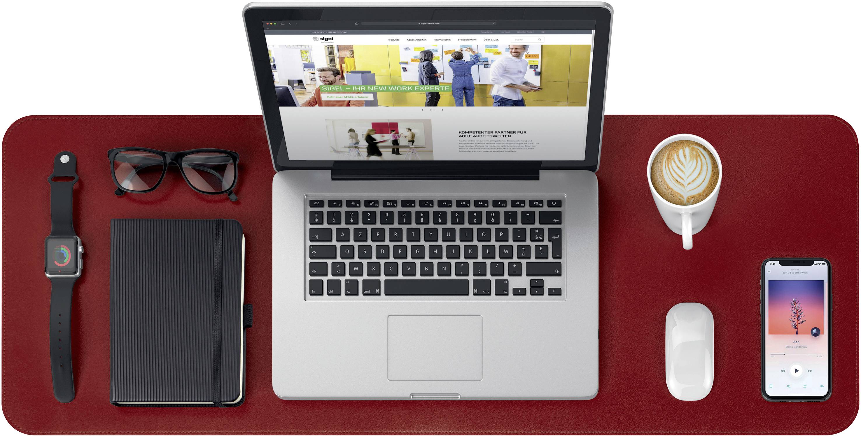 Laptop auf einem roten Schreibtisch, umgeben von einer Uhr, Notizbuch, Sonnenbrille, einer Tasse Kaffee, einer Maus und einem Smartphone.