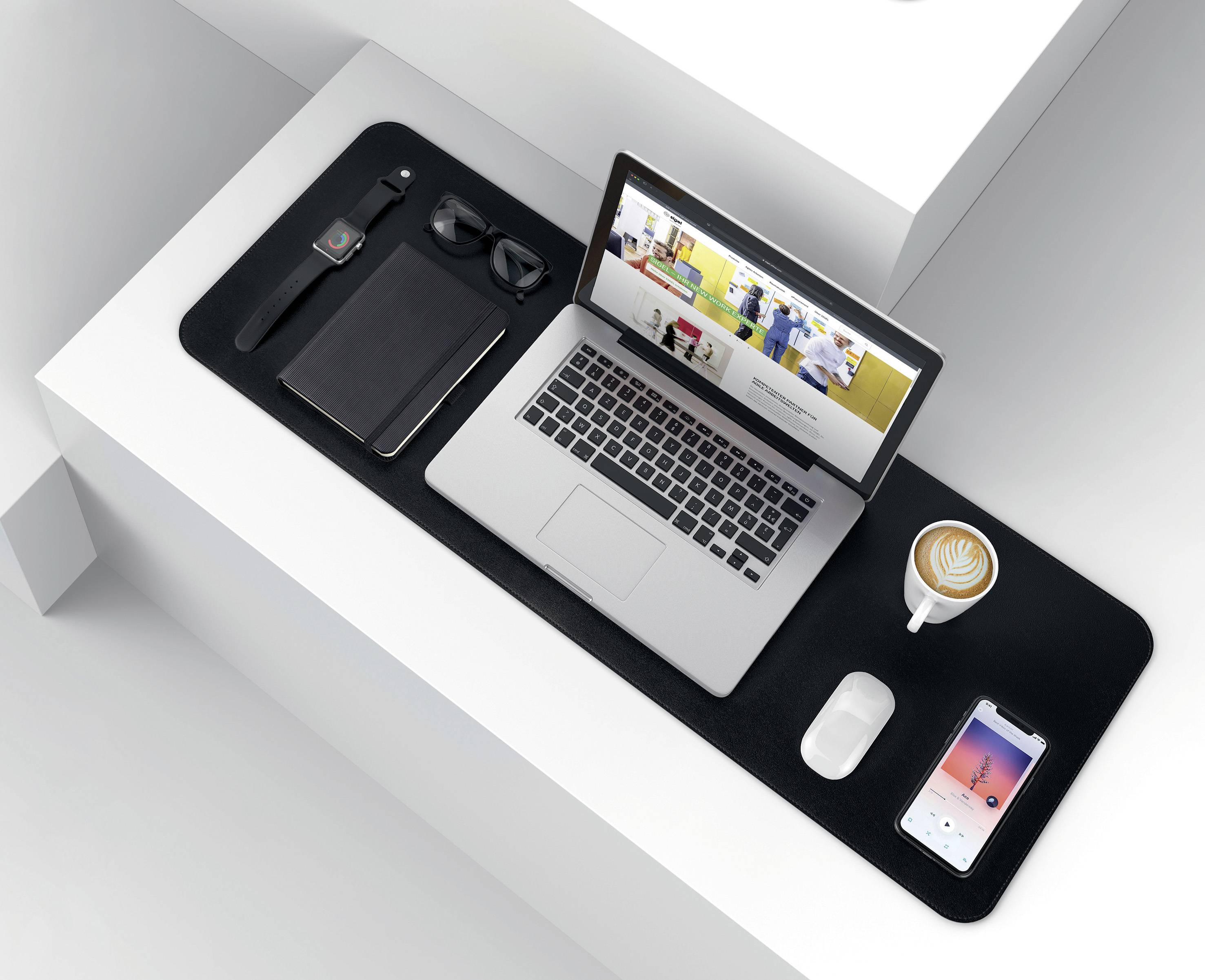 Laptop auf einem Schreibtisch mit geöffnetem Browserfenster, daneben eine Tasse Kaffee, Smartphone und Büroaccessoires. Moderne, aufgeräumte Arbeitsumgebung.