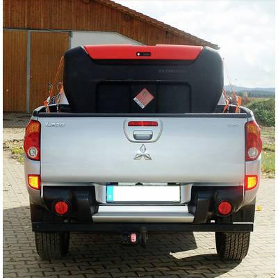 Ein silberner Pickup-Lkw mit geöffneter Heckklappe transportiert einen Motorroller mit orangenen Details auf einem gepflasterten Hof.