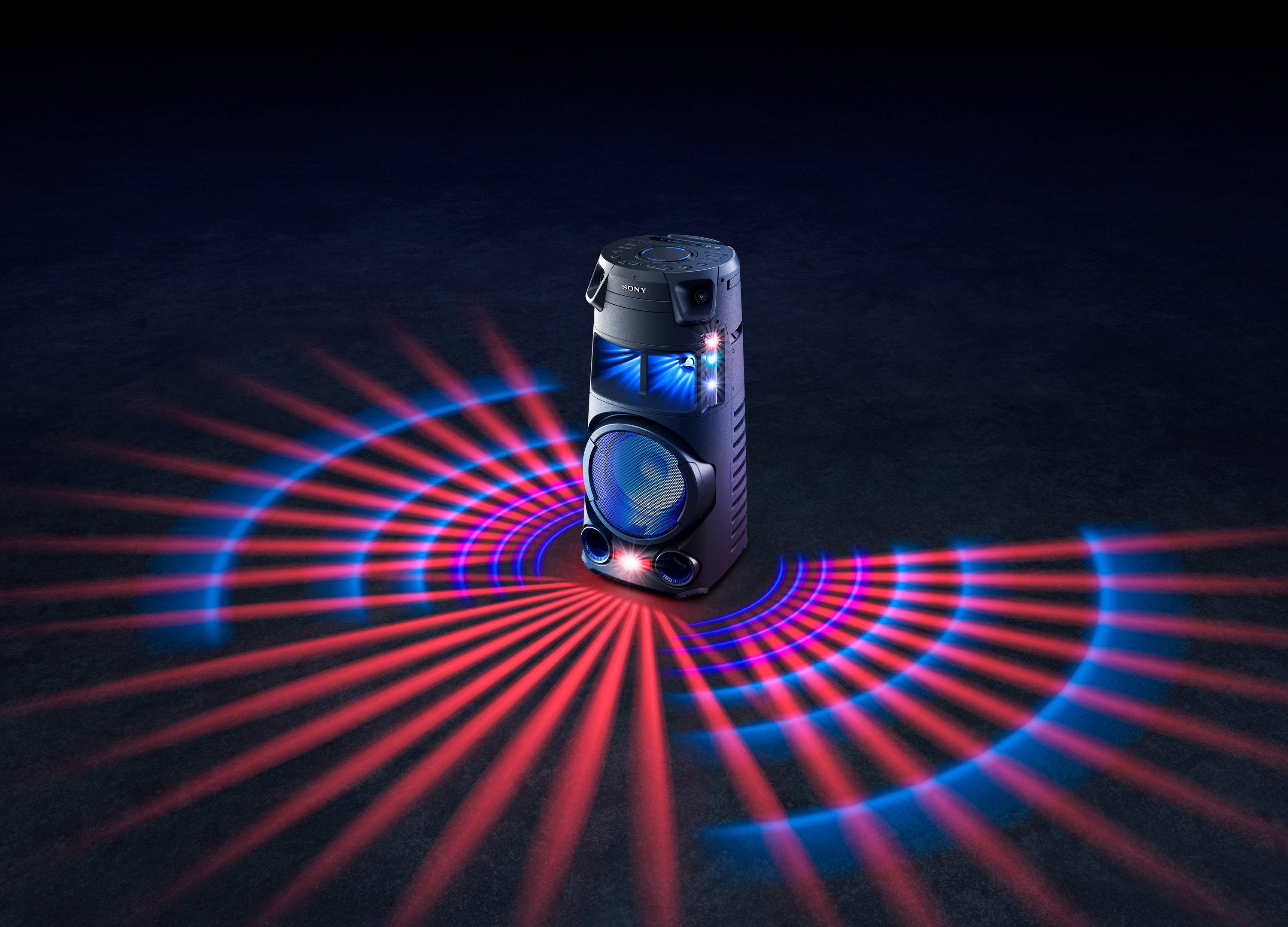 Party-Lautsprecher mit bunten Lichtern, die kreisförmig auf dem Boden strahlen, auf dunklem Hintergrund.