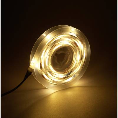 Eine aufgerollte LED-Lichterkette strahlt warmes, gelbes Licht aus und liegt auf einem dunklen Hintergrund.