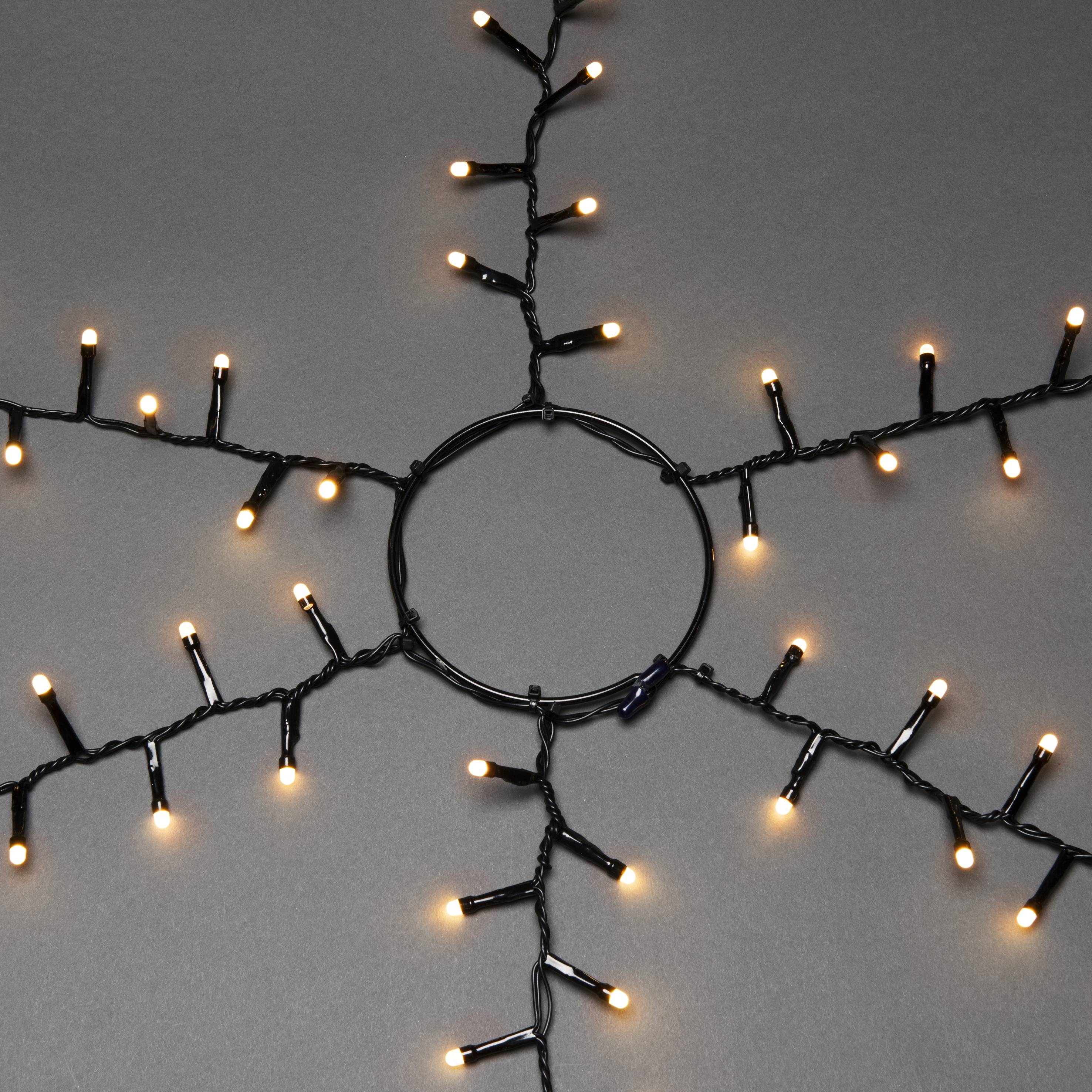 Schmucklichter in Sternform mit warmem, gelbem Licht auf grauem Hintergrund. Ideal für festliche Dekorationen.