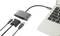 Ein Laptop mit einem angeschlossenen USB-Hub, der über HDMI-, VGA- und USB-Anschlüsse verfügt. Drei Kabel sind mit dem Hub verbunden.