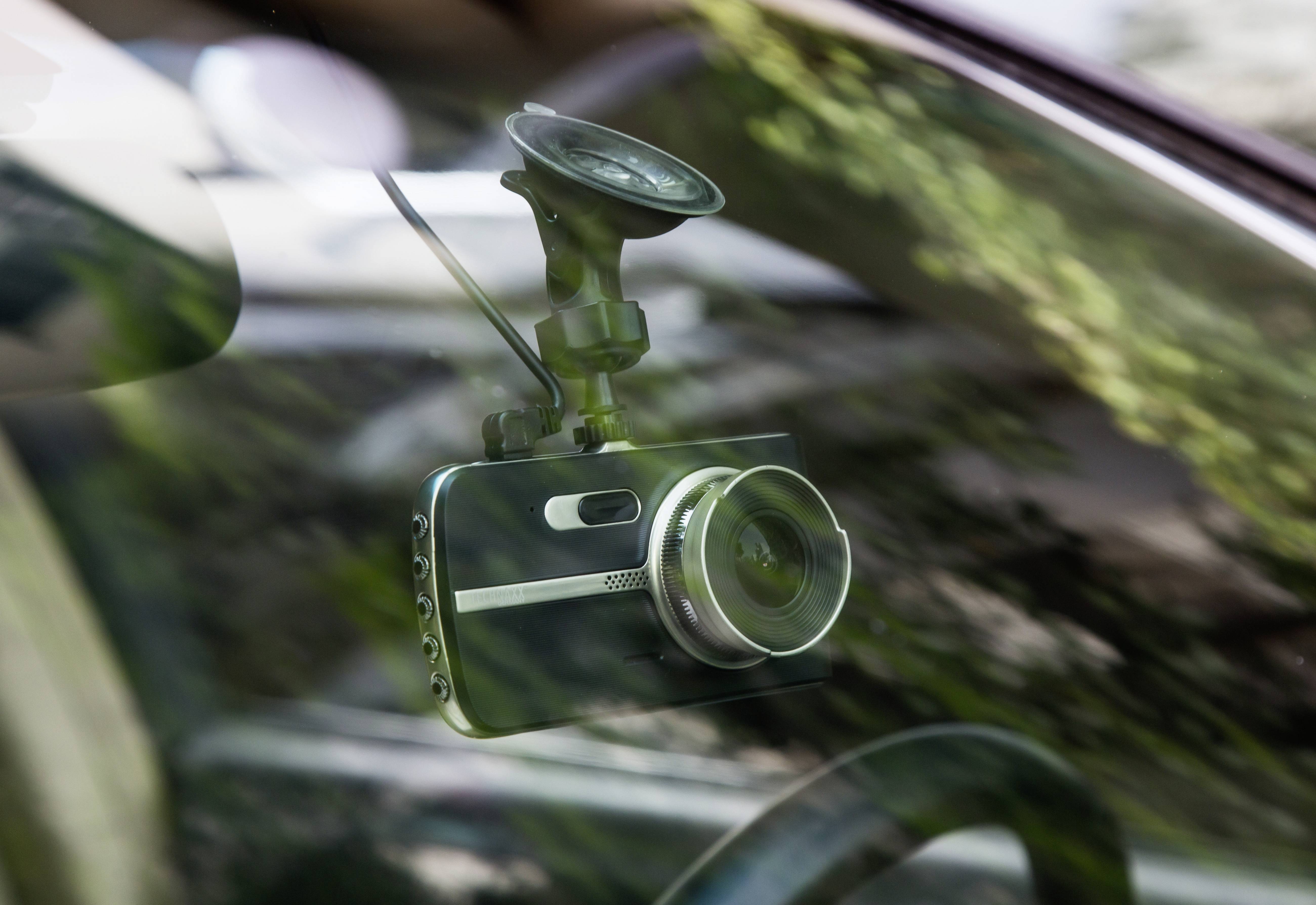 'Dashcam' befestigt an der Windschutzscheibe eines Autos. Sie zeigt nach außen und wird durch eine Saugnapfhalterung gehalten.