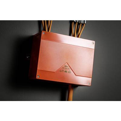 Ein orangefarbener Verteilerkasten ist an einer schwarzen Wand montiert. Mehrere Kabel ragen aus der oberen Seite heraus.