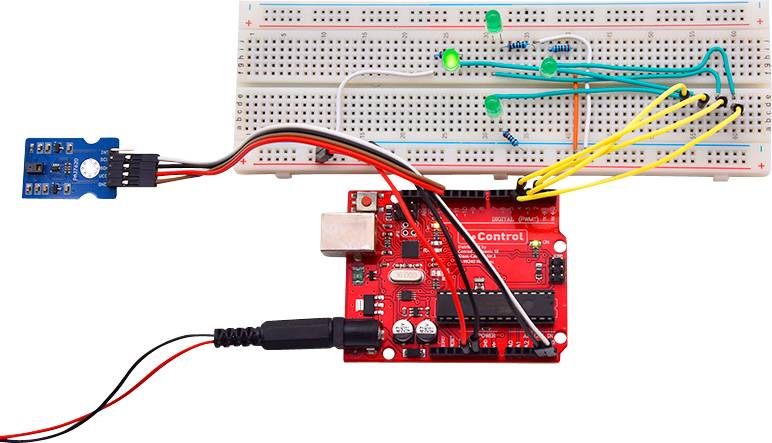 Rote Steuerplatine verbunden mit Steckbrett, grüne LEDs und Sensor. Elektronisches Schaltungsprojekt demonstriert Steuerung.